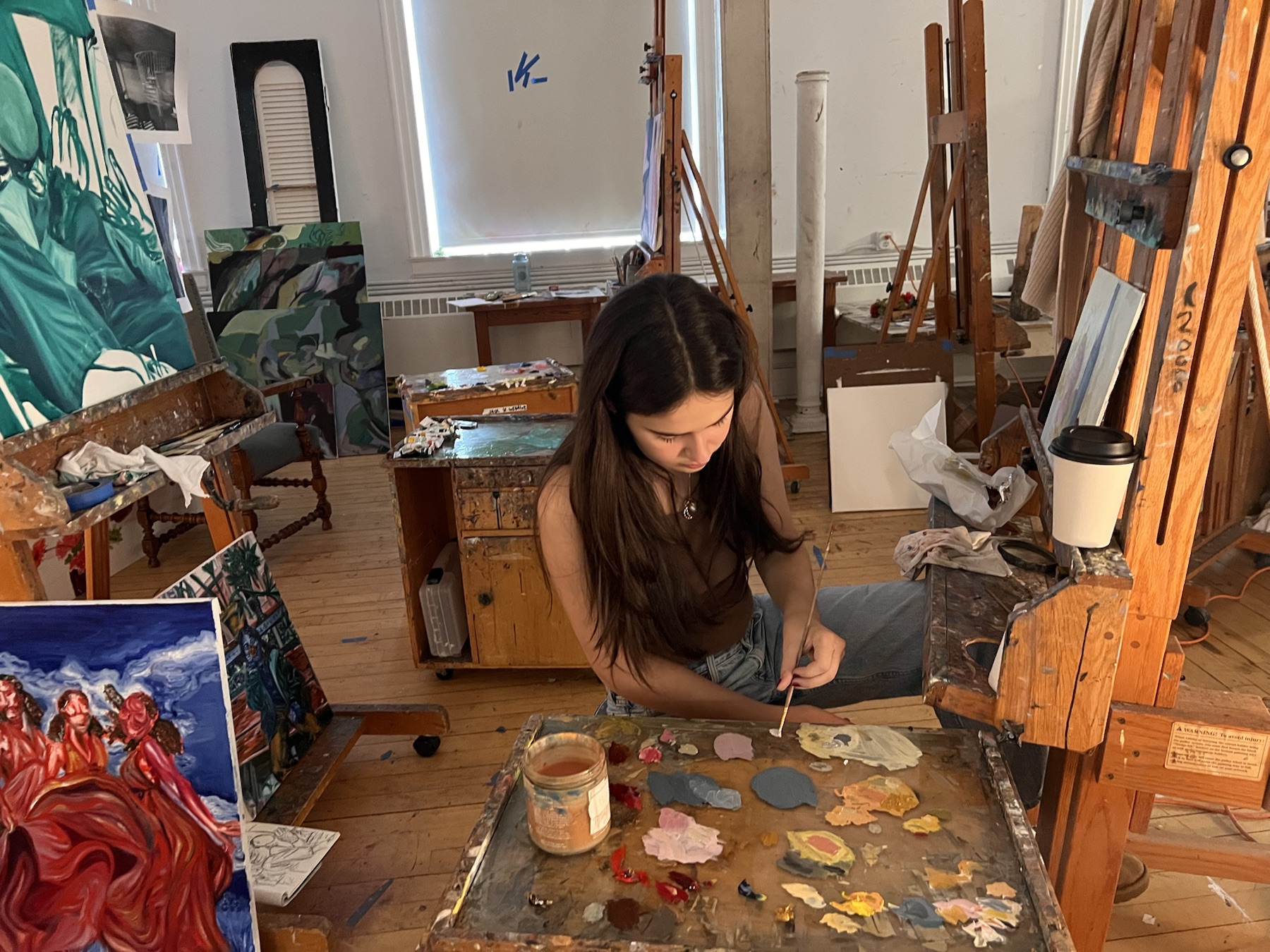 Leigh working at her palette in the painting studio