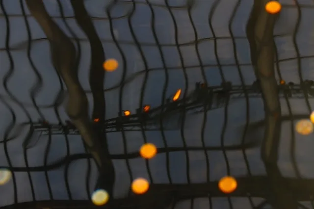 Abstract reflection of warm lights against a gridded structure